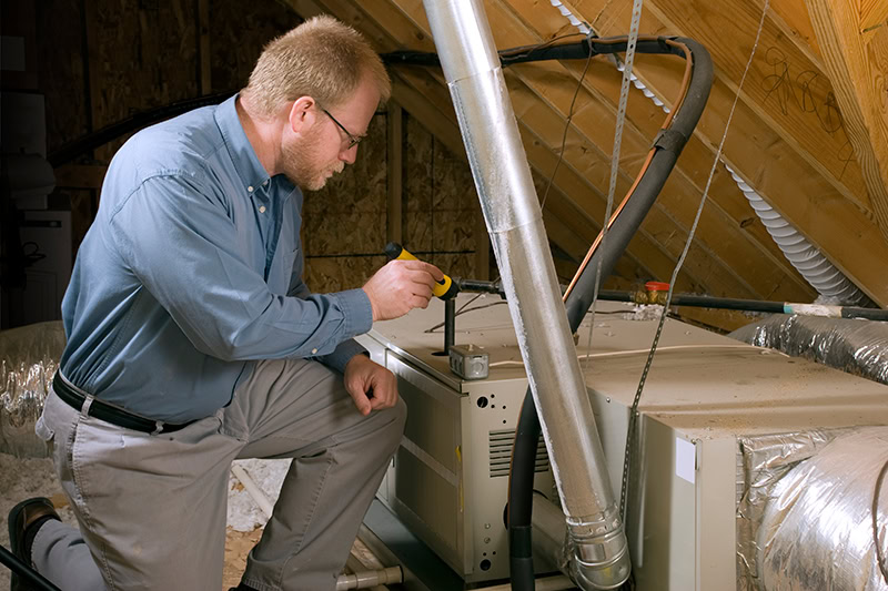 HVAC technician performing maintenance on a furnace.