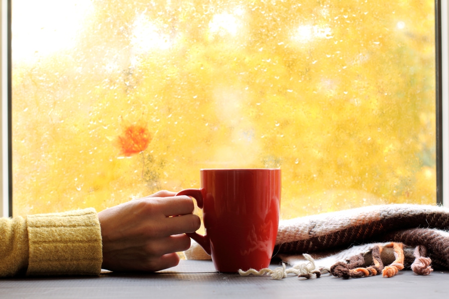 red mug of hot drink, when behind a window is rain in autumn in Midlothian, VA