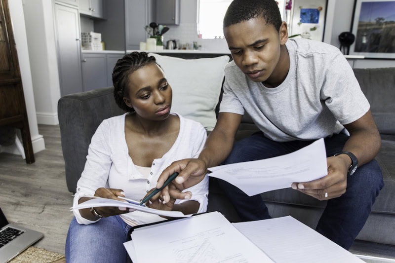 What Does an HVAC Maintenance Inspection Include? Young african female and male couple at home working on their finances together.